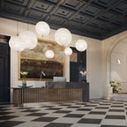 This Clérachic pendant's spheres seen from the entrance, hanging over a long reception desk and a black-and-white chequered floor.