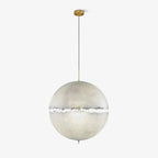 A sphere on a slim cord and brass-toned canopy, this Clérachic pendant on a pale plain backdrop.