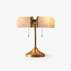 A Clérachic gold table lamp with twin white ribbed glass shades and two pull chains, lit warm on a plain white backdrop.