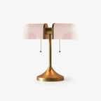 Pictured here, a Clérachic gold table lamp with pale pink ribbed glass shades, unlit, on a plain white backdrop.