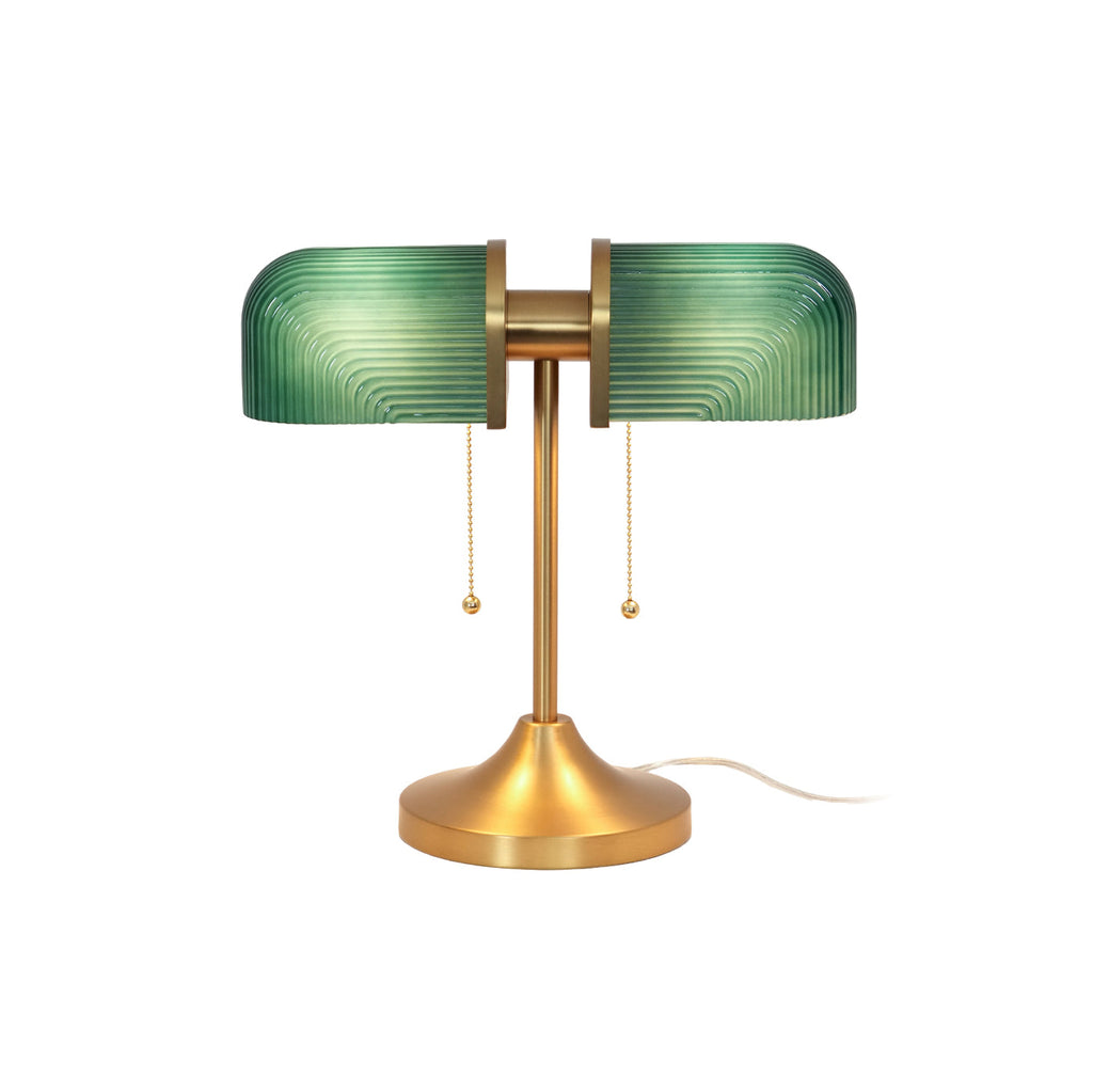 Shown here, a Clérachic gold table lamp with green ribbed glass shades and two pull chains, on a plain white backdrop.