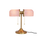 In this photo, a Clérachic gold table lamp with pink ribbed shades and its black cord, shown on a plain white backdrop.