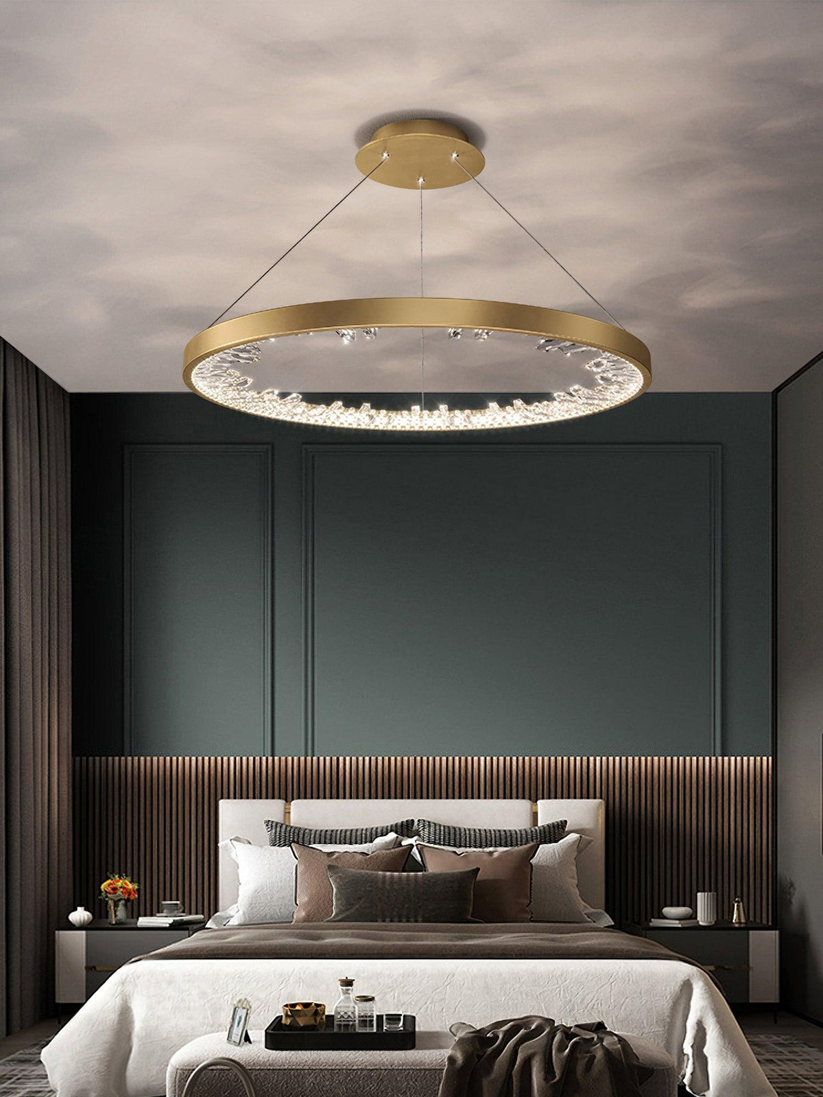 Gold Clérachic ring pendant light over a bed in a dark green room with wood slats and a cream bedspread.