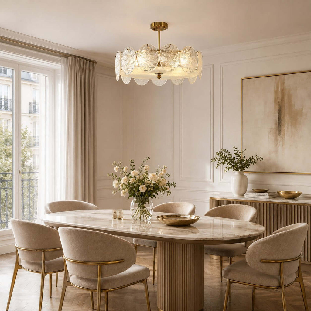 Gold semi flush Clérachic ceiling light with rippled glass discs, hanging above an oval marble dining table and boucle chairs.