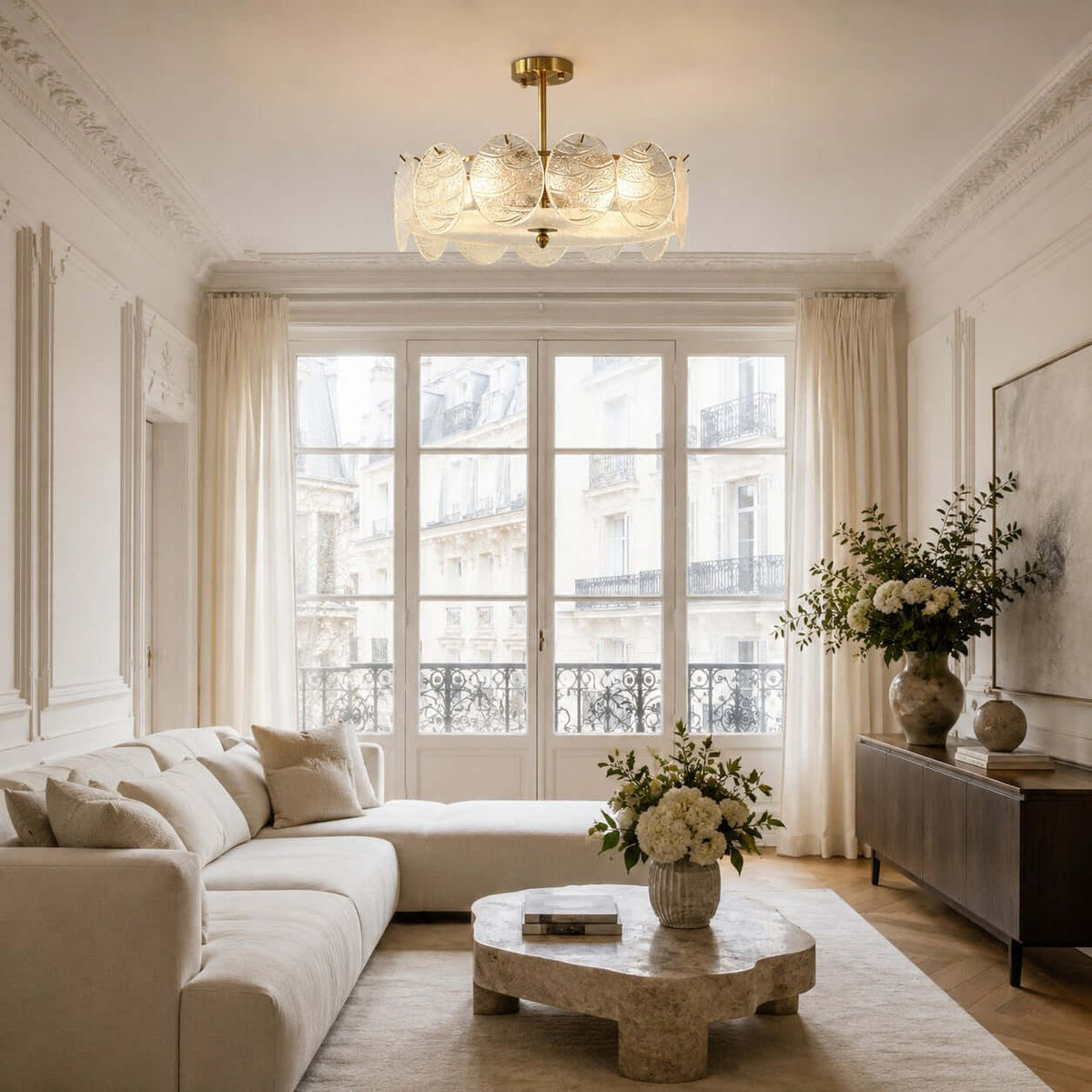 In a bright living room with a cream sofa and a stone coffee table, a Clérachic glass disc ceiling light sits close to the ceiling.