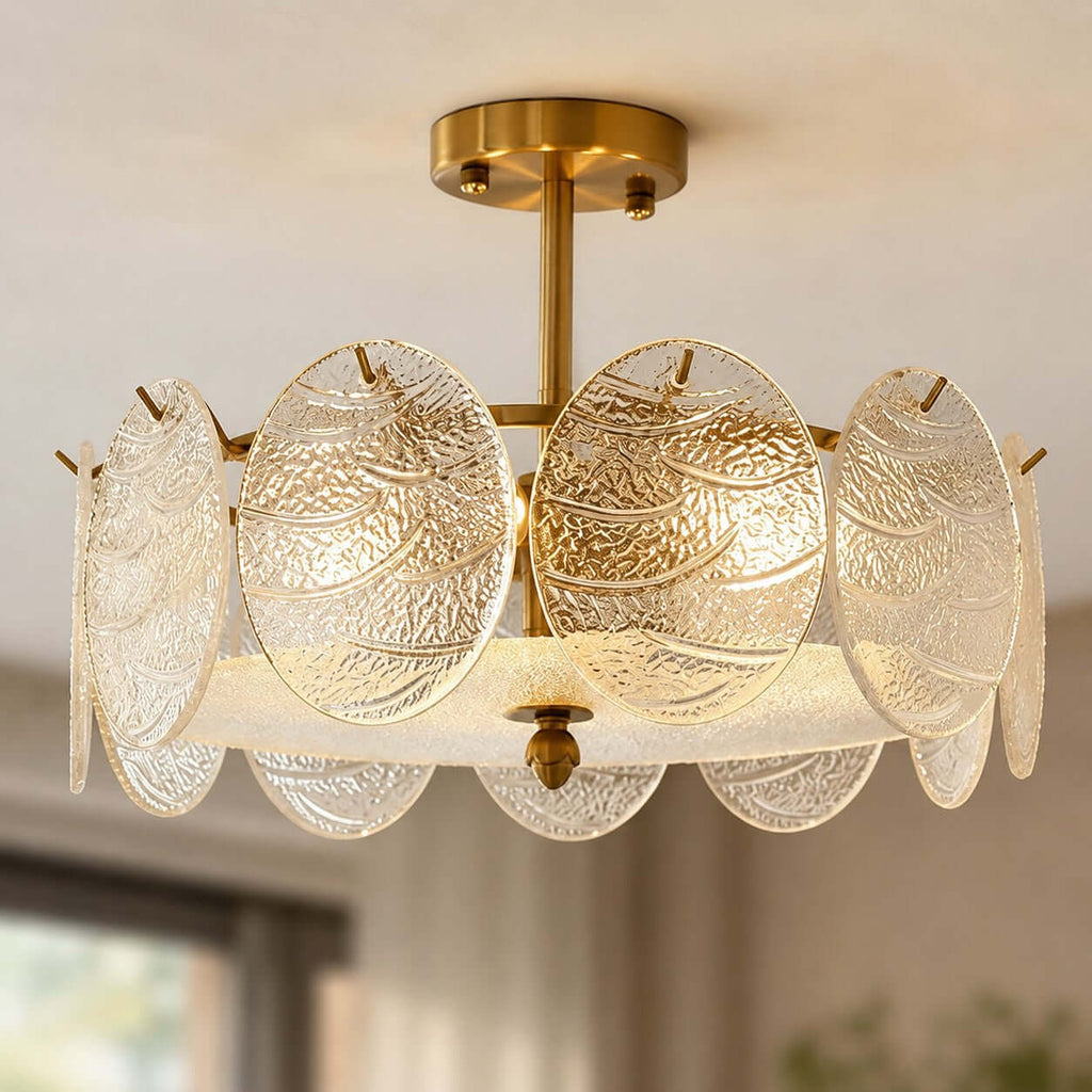 Close view of the rippled glass discs and brass canopy on this Clérachic semi flush ceiling light, lit warmly with a blurred room behind.
