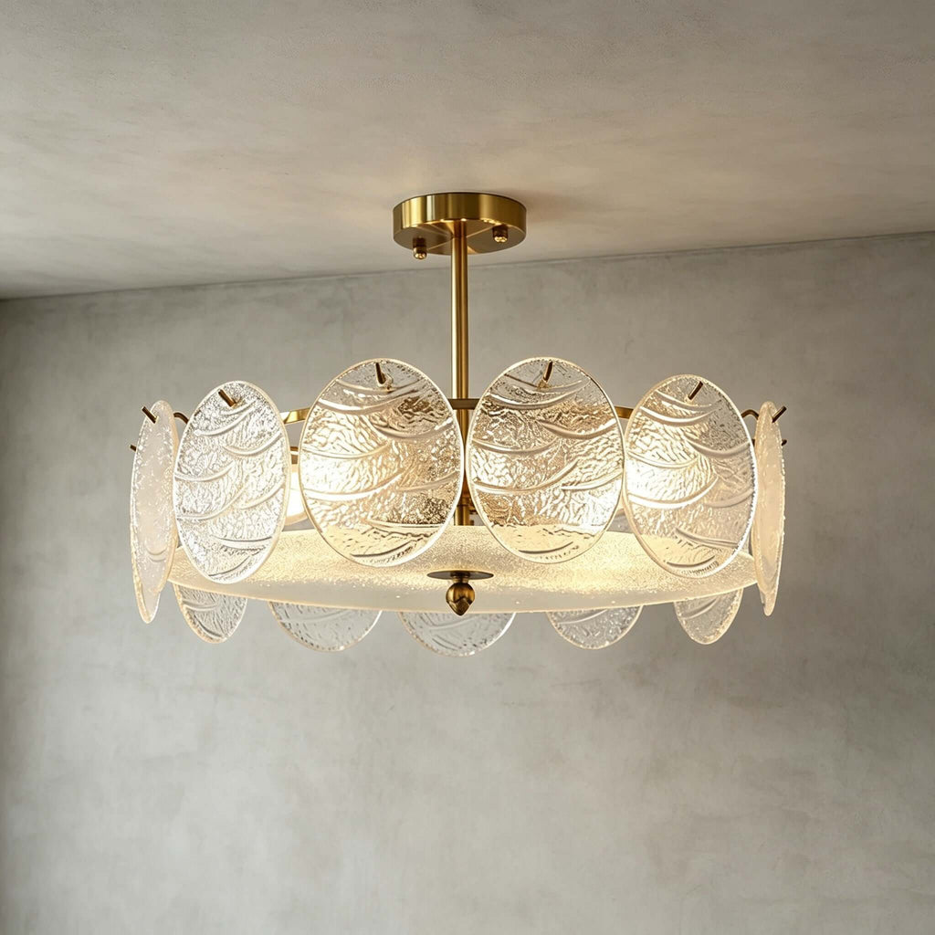 A Clérachic semi flush ceiling light with a gold canopy and overlapping glass discs, lit and photographed against a grey limewash wall.