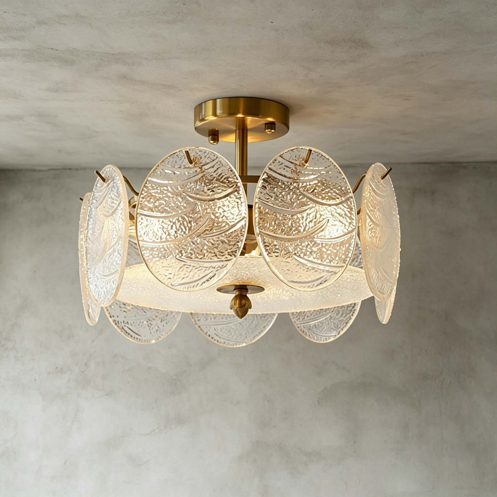 Angled close view of this Clérachic ceiling light, its gold canopy and textured glass discs glowing against a grey textured ceiling.