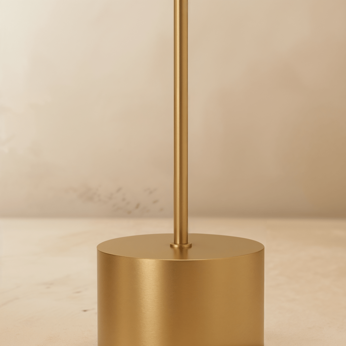 Clérachic table lamp detail in brushed gold, close-up of the slim stem meeting the cylindrical base.
