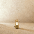 This Clérachic table lamp in a brushed gold base glows warmly through its vintage-style glass bulb shade.