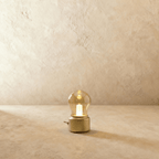 This Clérachic table lamp in a brushed gold base glows warmly through its vintage-style glass bulb shade.