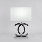 Clérachic chrome table lamp with a white rectangular shade on a polished stainless steel base, against a pale grey backdrop.