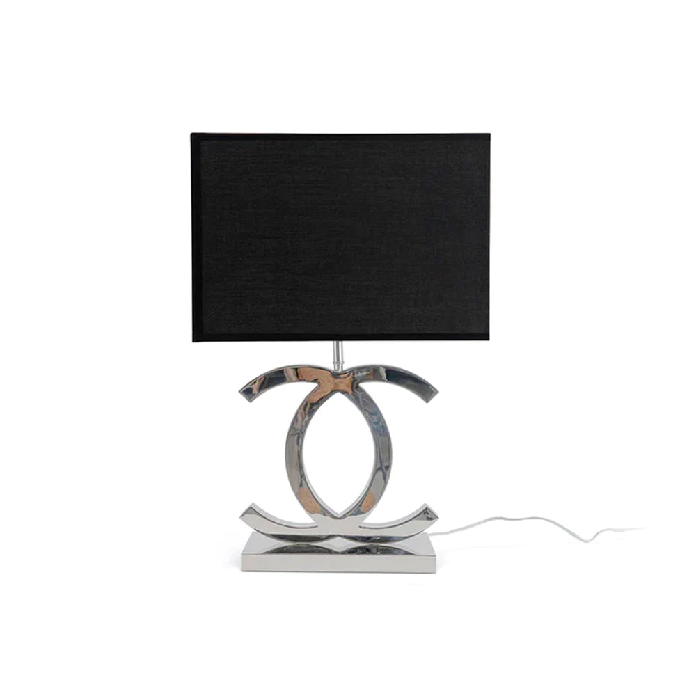 Clérachic chrome table lamp with a black rectangular shade and a polished steel base on a white backdrop, with a thin cord to the side.