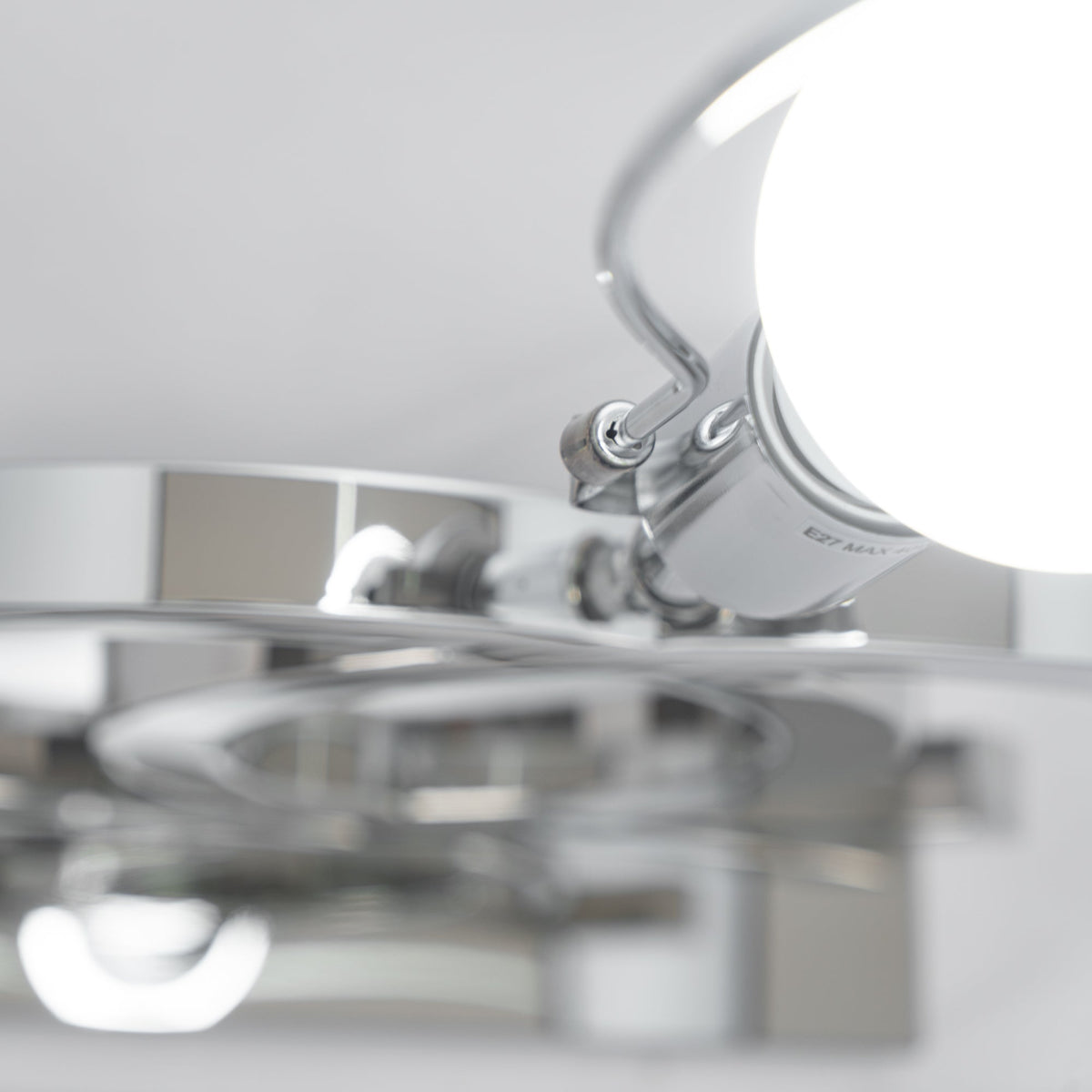 Close view from underneath of the bulb holder and the shiny steel parts inside the shade of this Clérachic table lamp.