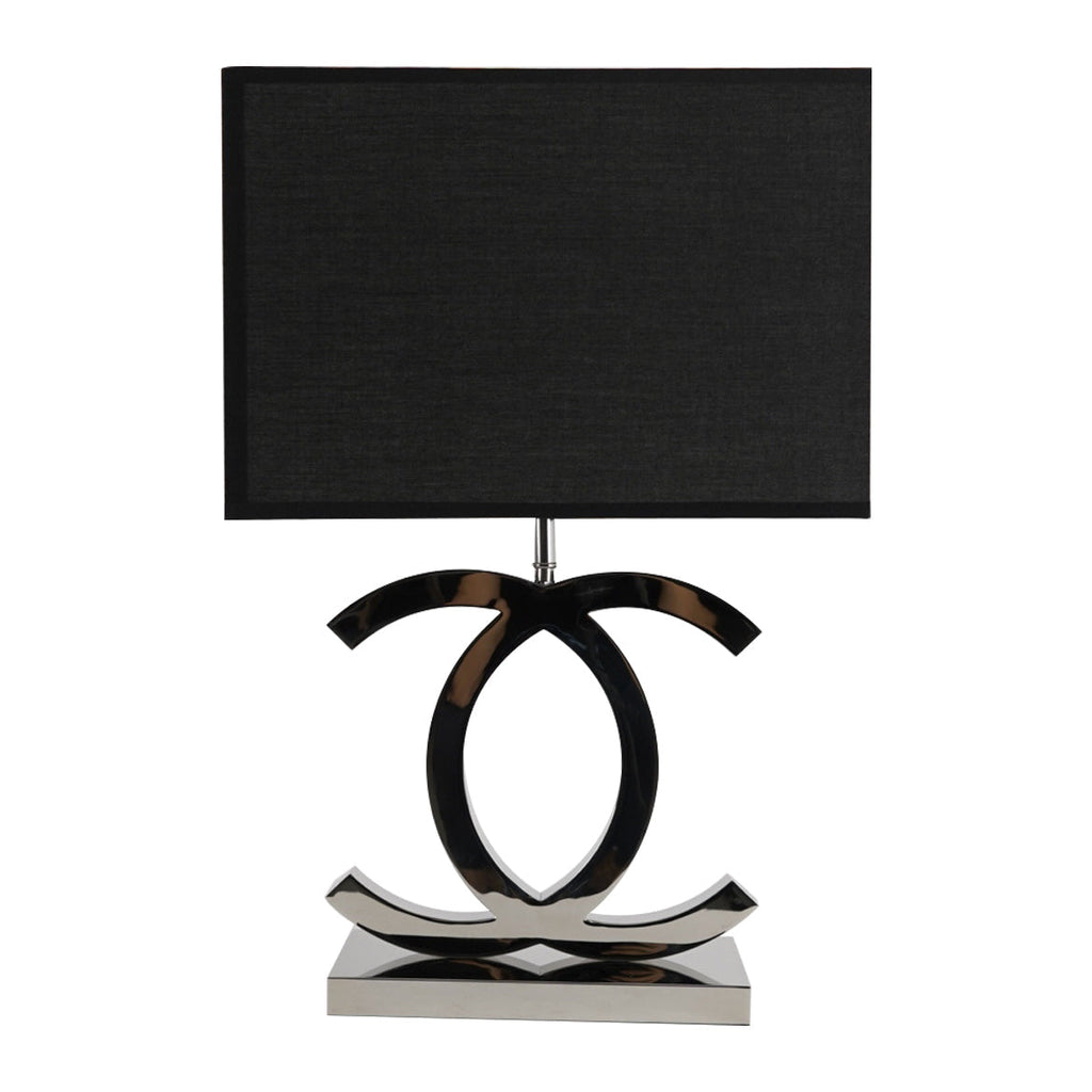 Clérachic table lamp with a black rectangular shade over dark chrome loops on a polished steel base, on a white backdrop.