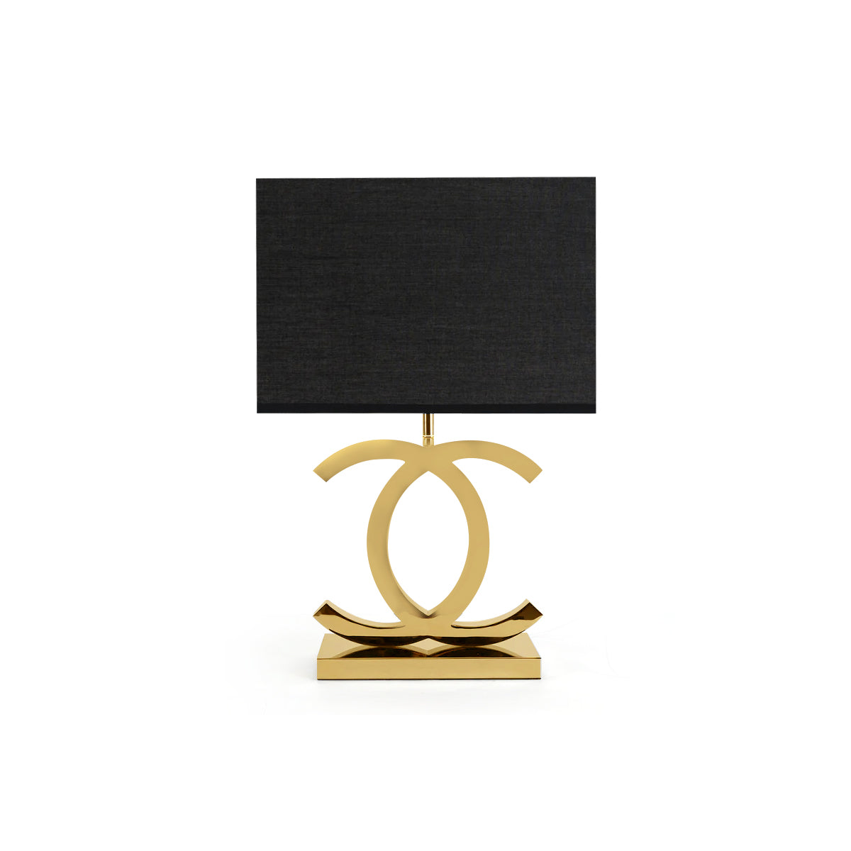 Clérachic gold table lamp with a black rectangular shade, its polished gold loops on a stepped gold base, on a white backdrop.