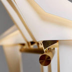 Close view of the gold pivot arm and folded white wings where the bird of this Clérachic lamp balances on its stand.