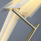 Very close view of the gold bar and hinge that hold the glowing folded bird of this Clérachic table lamp.