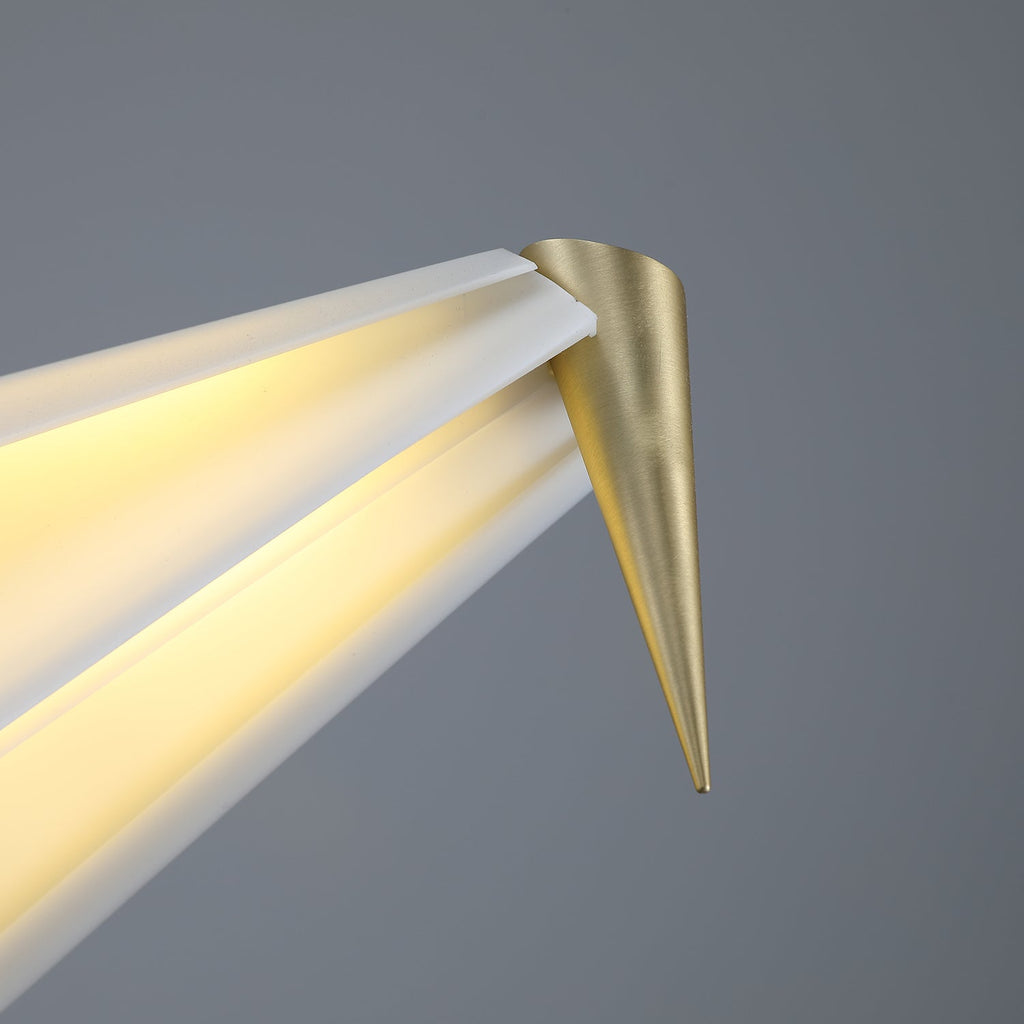 Close view of the gold cone tip at the end of the bird's tail on this Clérachic table lamp, with light along the fold.