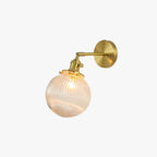 Clérachic Gold Vanity Wall Sconce with a ribbed clear glass globe on a short gold arm, studio view.