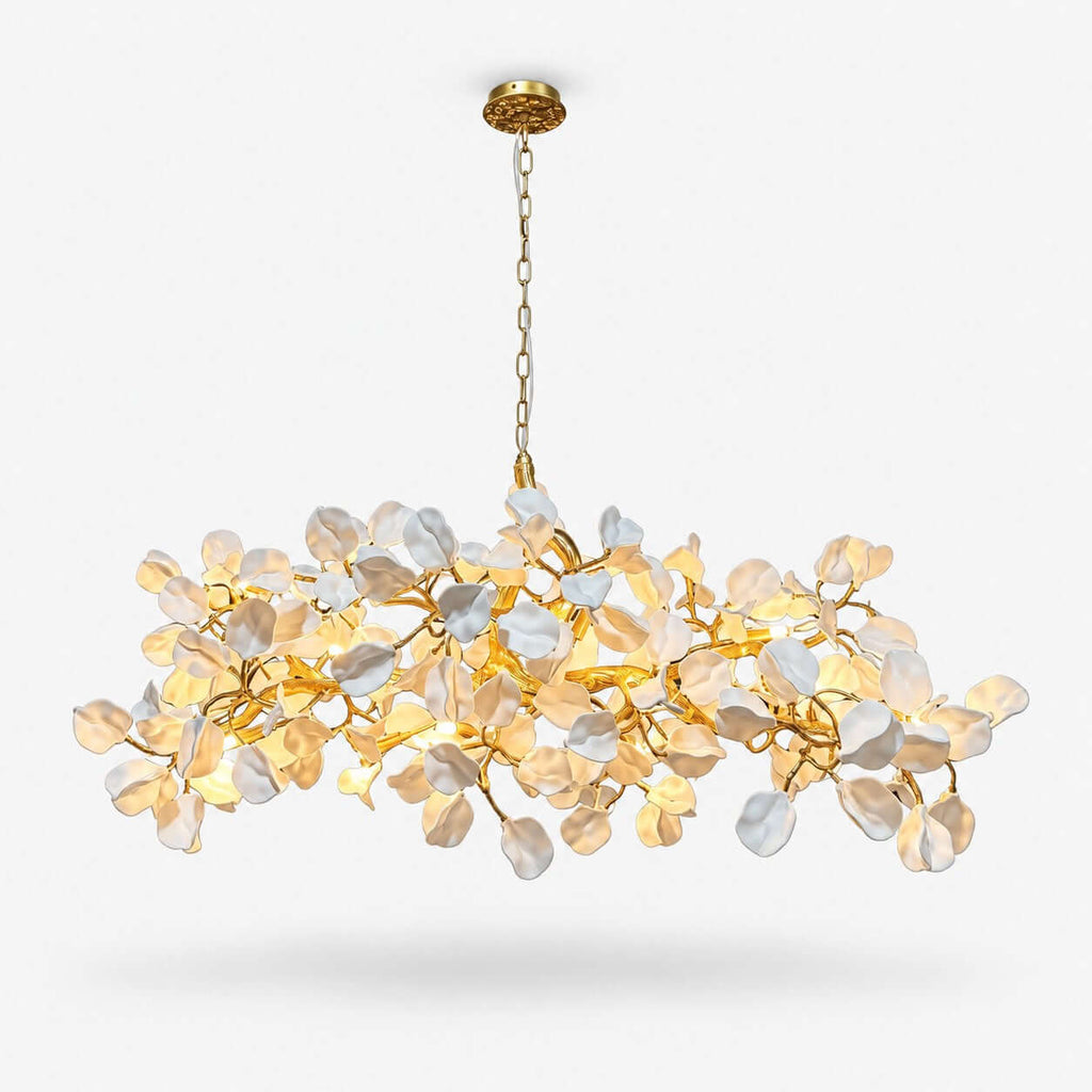 This Clérachic linear chandelier on a plain white background, a cloud of white ceramic petals on a gold vine frame hung from a gold chain.