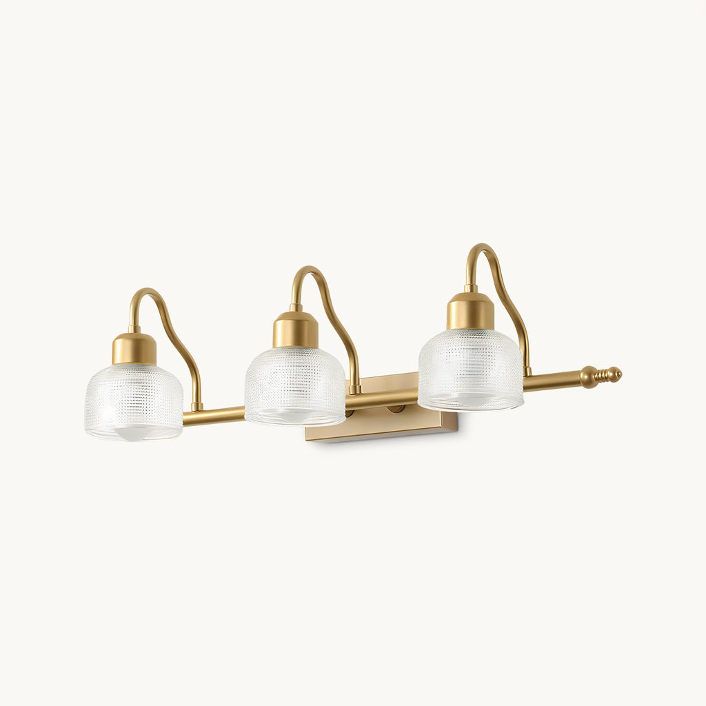 Three-light gold wall lamp with curved brass arms and ribbed glass shades, shown on a plain white backdrop as this Clérachic design.