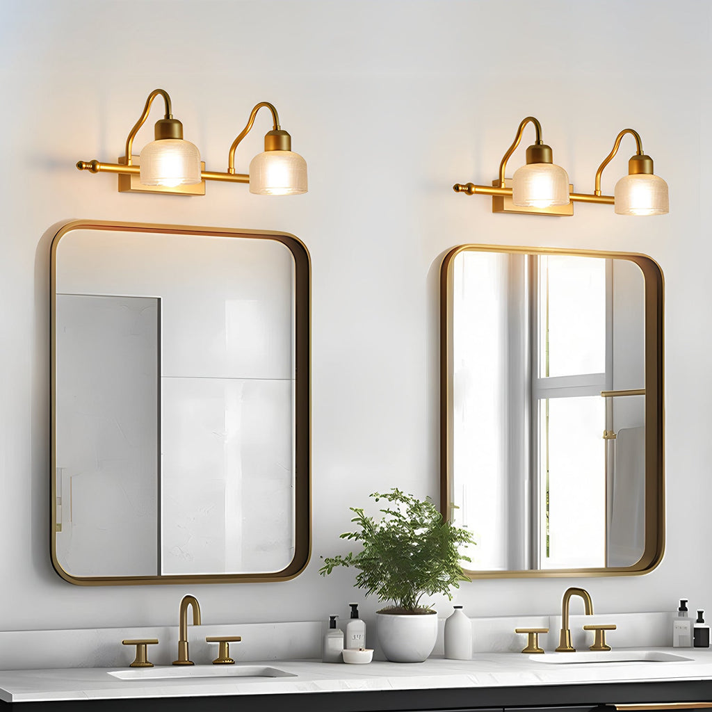 A pair of two-light Clérachic wall lamps above two rounded mirrors over a double vanity, with a potted plant between the basins.