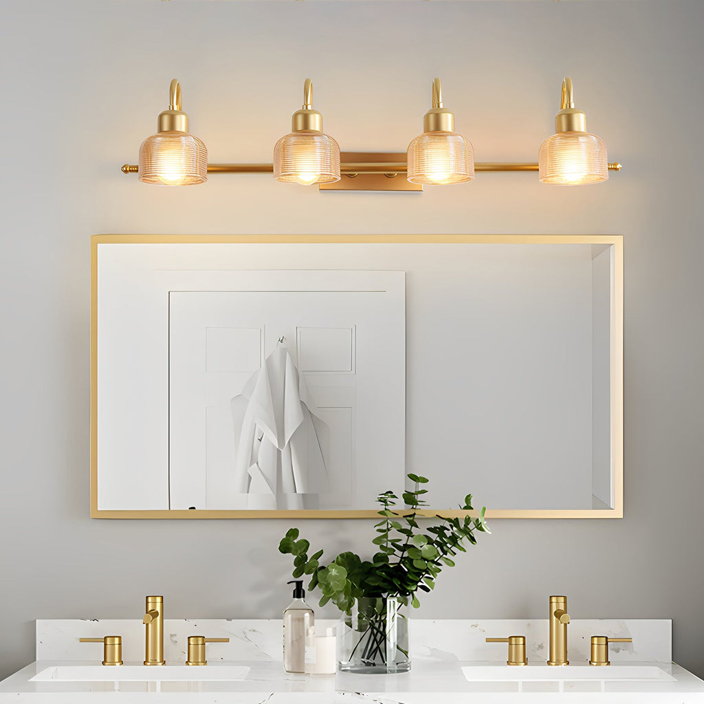 Four-light Clérachic wall lamp running above a wide gold-framed mirror, with a white robe hanging on a door in the reflection.