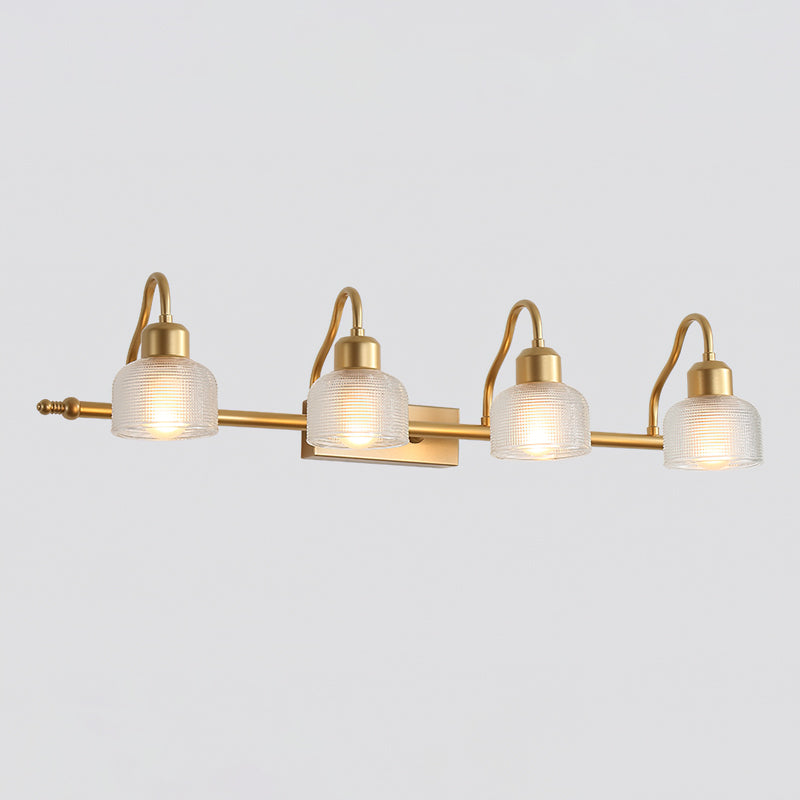 Four-light Clérachic wall lamp on a pale grey backdrop, with clear ribbed glass shades, curved gold arms and a long gold bar.