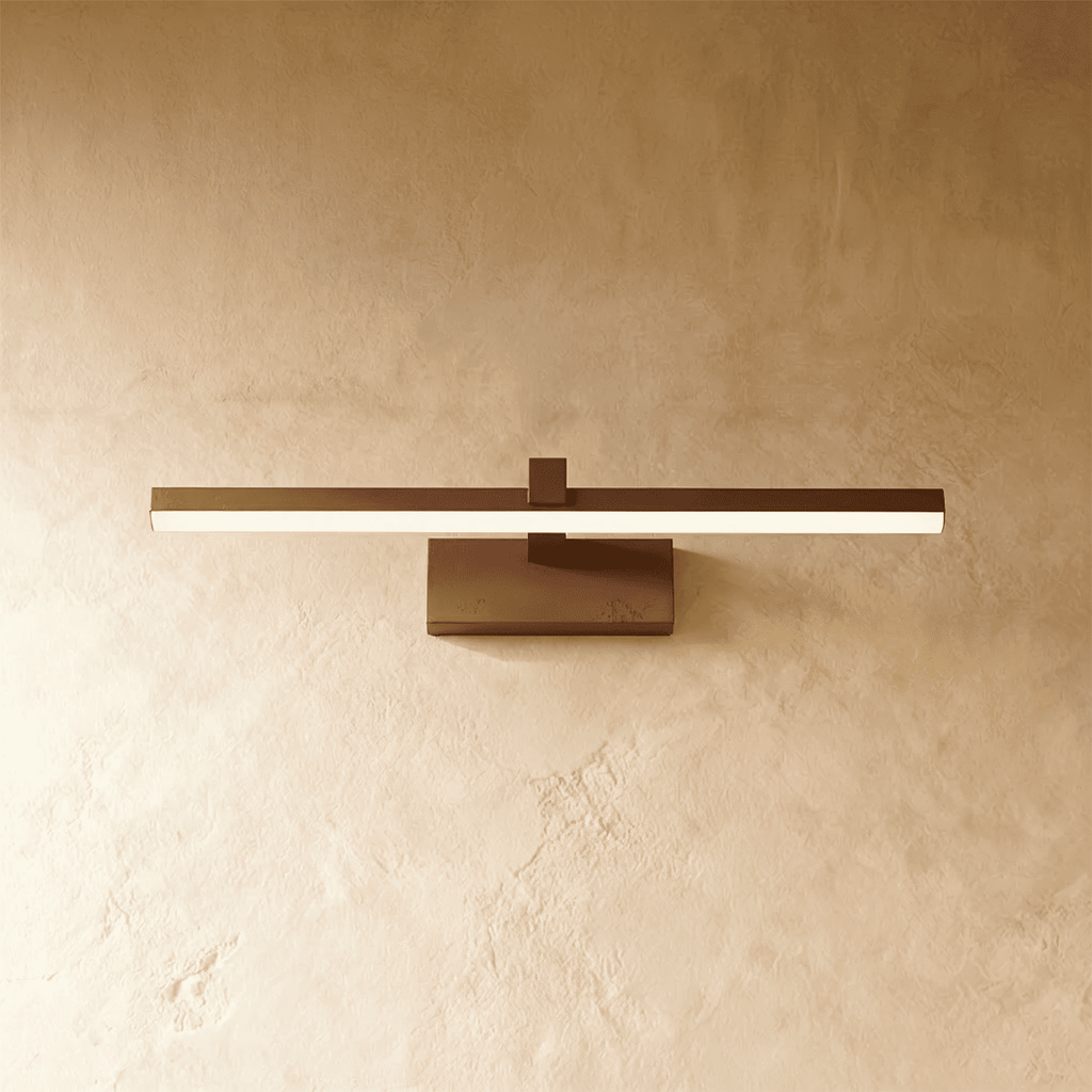Clérachic black linear wall light with a slim glowing bar mounted on a small rectangular plate against plaster.