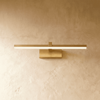 Clérachic brass linear wall light with a slender glowing bar mounted flush on a plaster wall via a small plate.