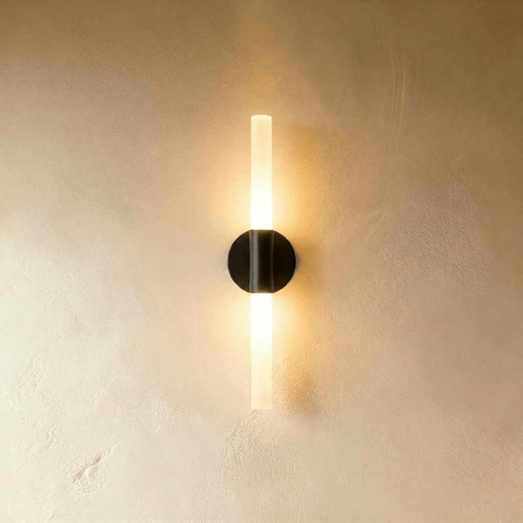 Clérachic Ena wall lamp in black with a frosted glass tube, its round disc mount centered on the wall.