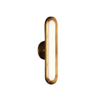 Side view of a single Clérachic capsule wall light, showing its gold rim and the shallow round brass plate behind it.