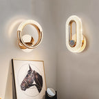 Clérachic gold ring wall lamp and oval stone-inlay wall lamp lit side by side above a framed horse print.