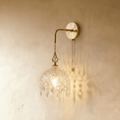 Clérachic gold-finished wall lamp with a cut-glass dome shade and crystal drops on a swan-neck arm with pull chain.