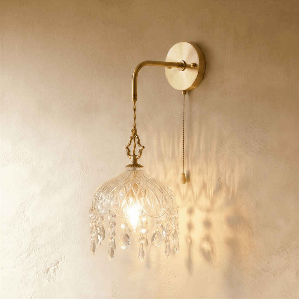 Clérachic wall lamp lit warm, its cut-glass shade and crystal drops casting patterned shadows on a plaster wall.