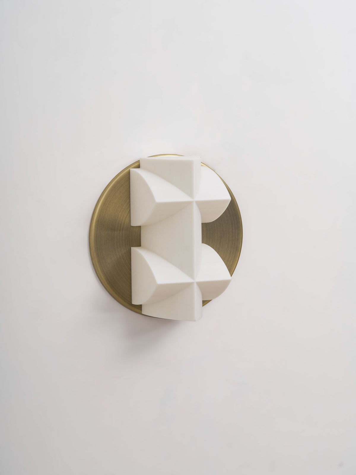 Unlit, this Clérachic sconce shows white spear-like facets turned slightly to the side on a brushed gold disc.