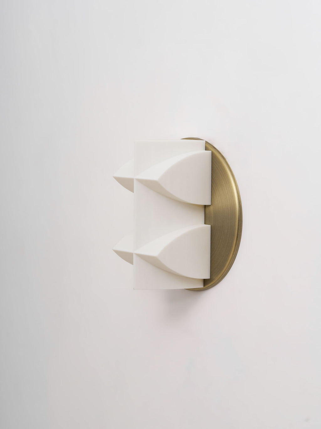 Side view of an unlit white Clérachic wall sconce, two curved points projecting from a brushed gold backplate.
