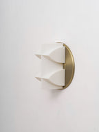 Side view of an unlit white Clérachic wall sconce, two curved points projecting from a brushed gold backplate.