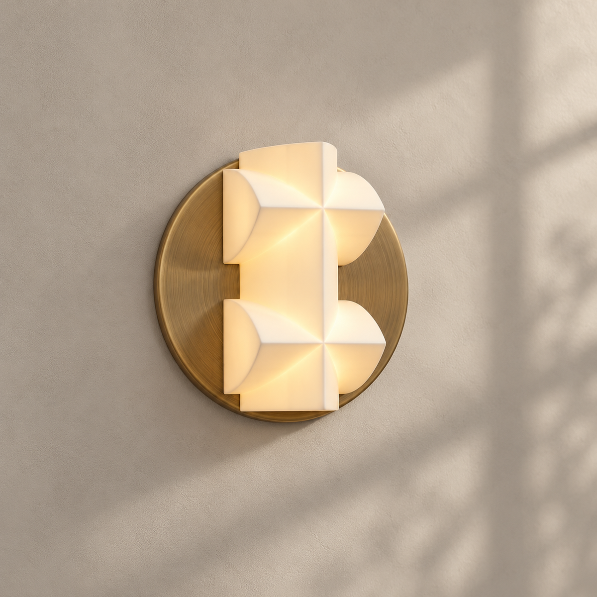 A lit Clérachic wall sconce on a large gold disc, with window shadows falling across a beige wall.
