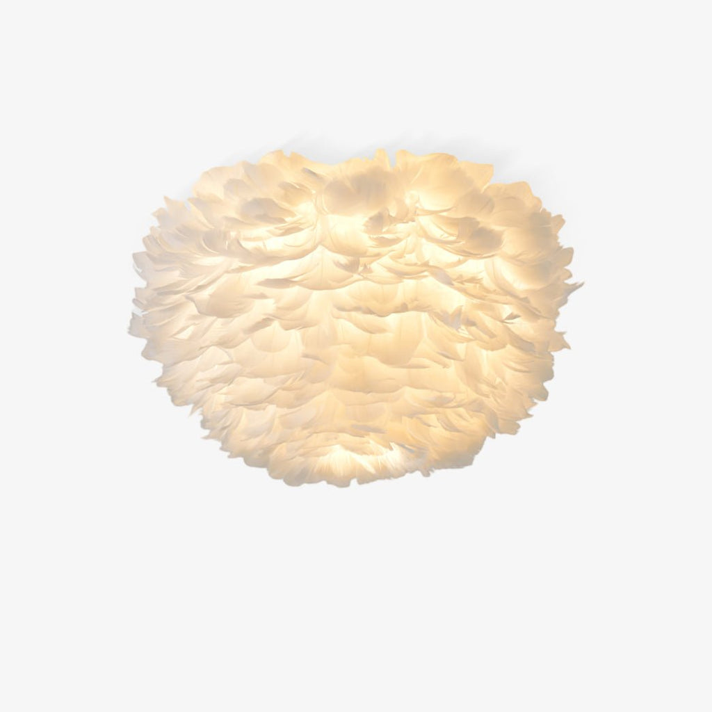 White goose-feather ceiling light from Clérachic glowing warm, with layered feathers forming a rounded shade, on a plain white backdrop.