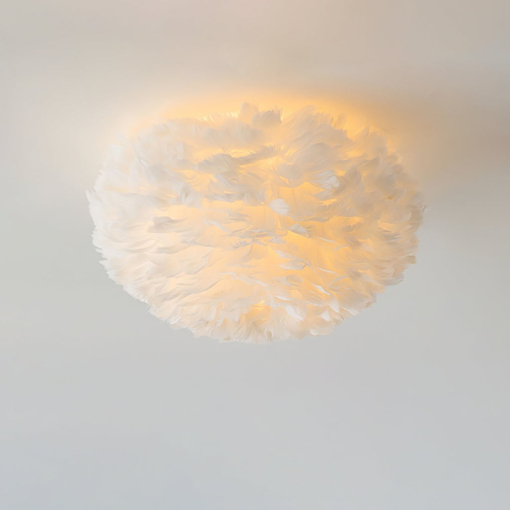 Close view of a white goose-feather ceiling light from Clérachic, lit warm so a soft halo spreads across the ceiling.