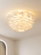 White feather ceiling light from Clérachic lit warm, seen from below in a room with an arched doorway and a corniced wall.