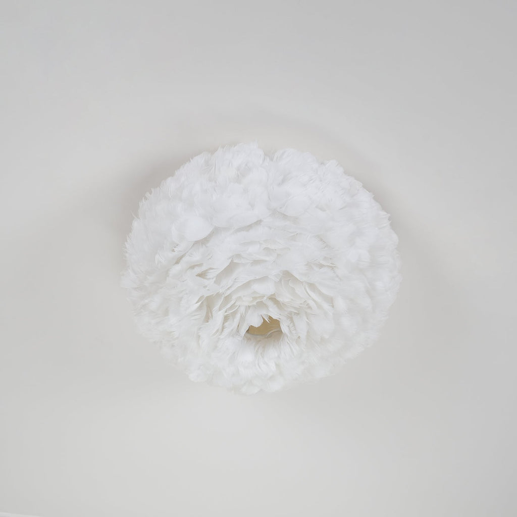Underside of a white feather ceiling light from Clérachic, showing the feathers swirling round a small central opening.