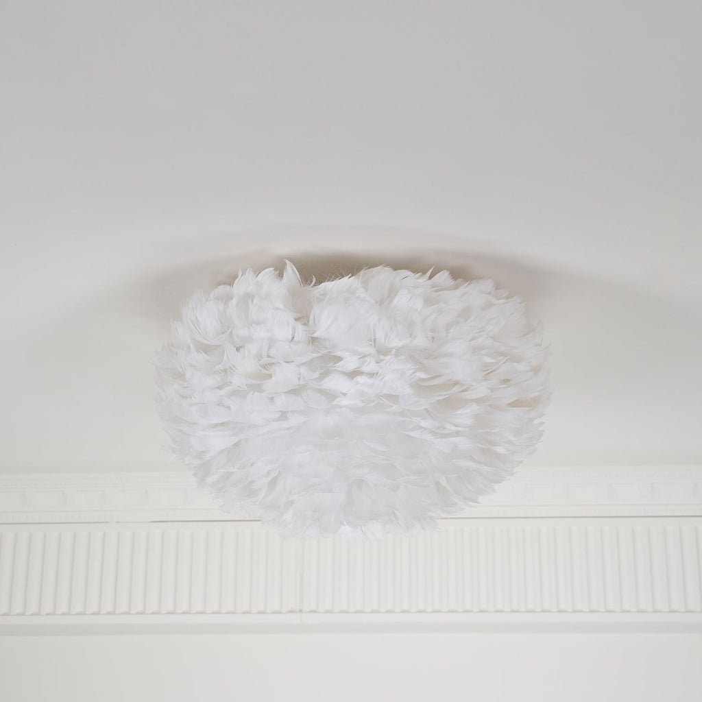 Unlit white feather ceiling light from Clérachic on a white ceiling above a ribbed plaster cornice, seen from the side.