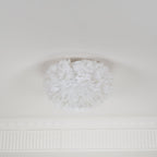 Small white feather ceiling light from Clérachic, unlit, on a pale ceiling with a decorative cornice below it.