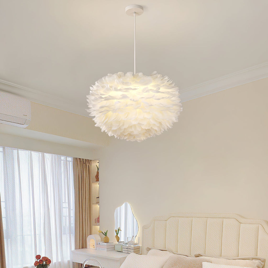 A dome-shaped Clérachic feather pendant glows warm white in a cream bedroom with a tufted headboard and a dressing table.