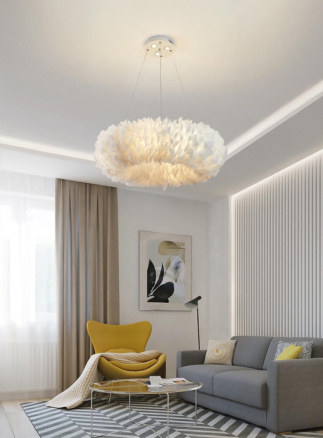 A Clérachic feather ring pendant hangs above a grey sofa, a yellow armchair and a round coffee table in a living room.