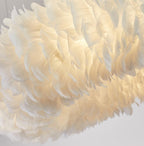 Close view of overlapping white feathers on this Clérachic pendant, lit warm from within.
