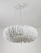 A Clérachic feather ring pendant unlit, showing the white feathers in layers, on three cables against a white wall.
